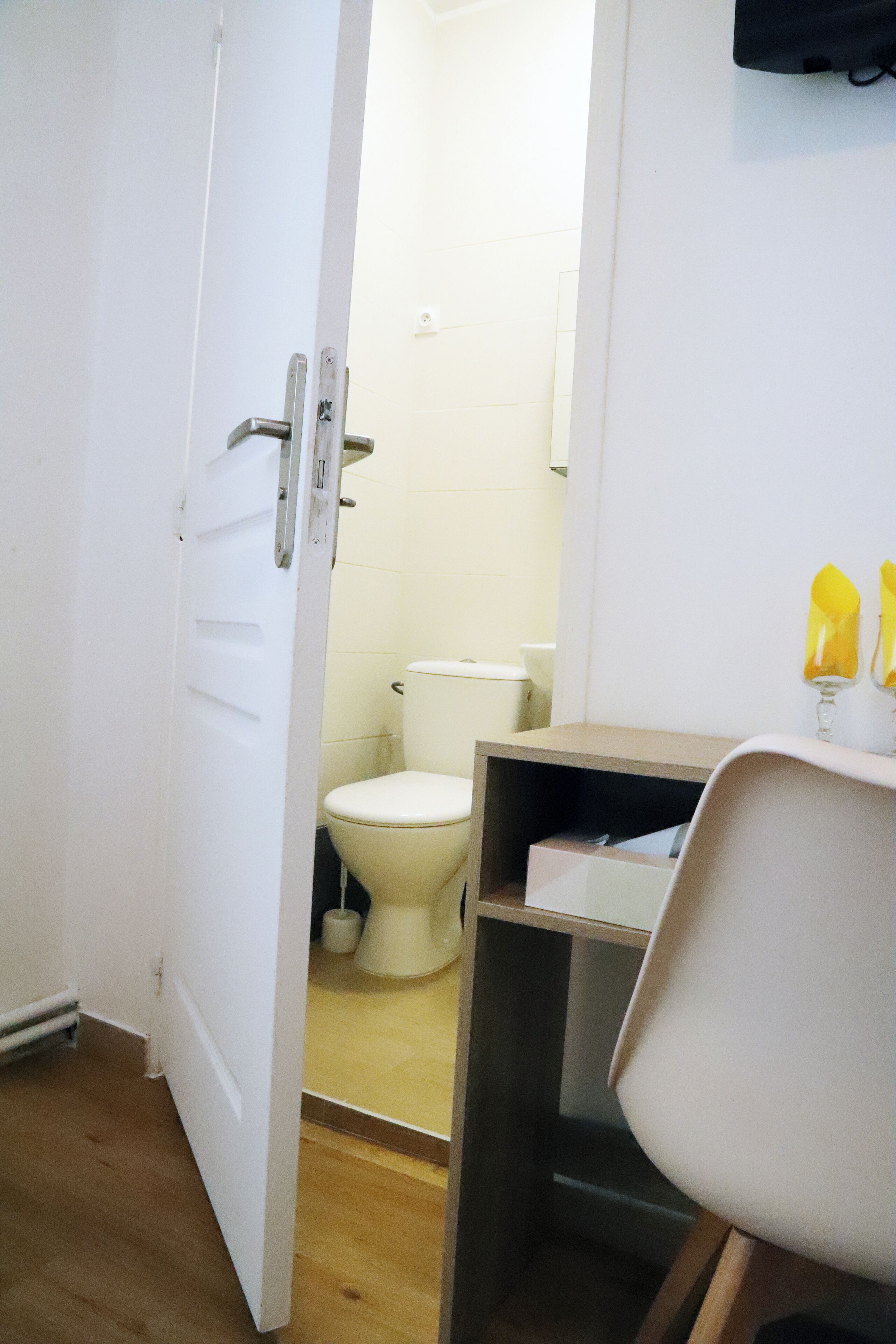 A bathroom with a toilet, a white sink, and a mirror.