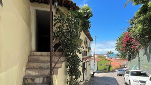 A cobblestone street leading to a building with a sign reading "CORES DA PIPA". - Cores da Pipa flats (Tibau do Sul)