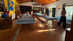 A spacious dining area with long tables, wooden ceiling beams, and a view of the outdoors. - Casa Vimeiro Sleeps 2 With Pets (Alcobaça)
