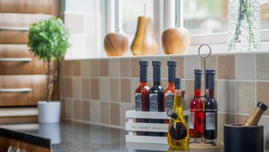 Una encimera de cocina con botellas de vino y una botella de aceite de oliva.