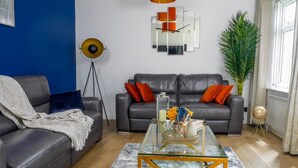 Una sala de estar moderna con un sofá de cuero, una mesa de centro de vidrio y un reloj de pared decorativo.