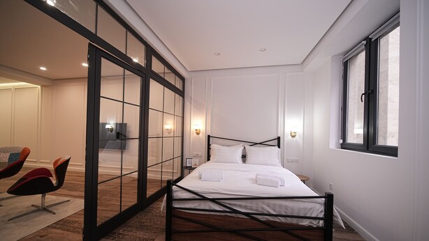 A modern bedroom with a large bed, a glass partition, and a window. - 2-bedroom luxury apartment in the center of Yerevan by Sweet Home (Yerevan)
