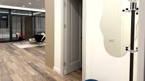 A modern hotel room with a wooden floor, a large mirror, and a door leading to another room. - 2-bedroom luxury apartment in the center of Yerevan by Sweet Home (Yerevan)