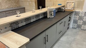 A kitchen with a wooden countertop, a coffee maker, and a clock on the wall. - House Air conditioning in the countryside Vouvray (Vouvray)