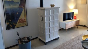 A modern living room with a white cabinet, a TV, and a lamp.