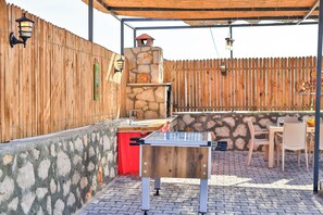 Enjoy al fresco dining in this patio area with a stone oven and comfortable seating for two.
