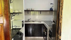 Una cuina pràctica amb rentaplat, fogó i una petita barra.