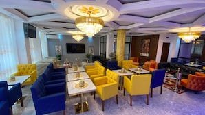 A hotel lobby with a mix of seating areas, including sofas and chairs, and a bar area. - Résidence hôtelière MEDOM Palace, Bastos (Yaoundé)