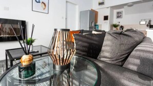 A modern living room with a glass coffee table, a decorative vase, and a sofa. - Loft Living Leigh-on-sea (Leigh-on-Sea)