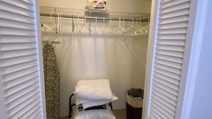 A small, enclosed bathroom with a shower, a toilet, and a storage cabinet. - Charming 2-bedroom apartment with WiFi and AC in Devonshire (Devonshire)