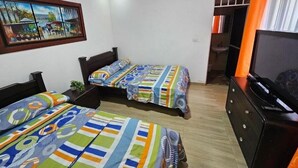 A room with two beds, a TV, and a painting on the wall. - Cabaña el árbol - Quadruple Room (Jagua)