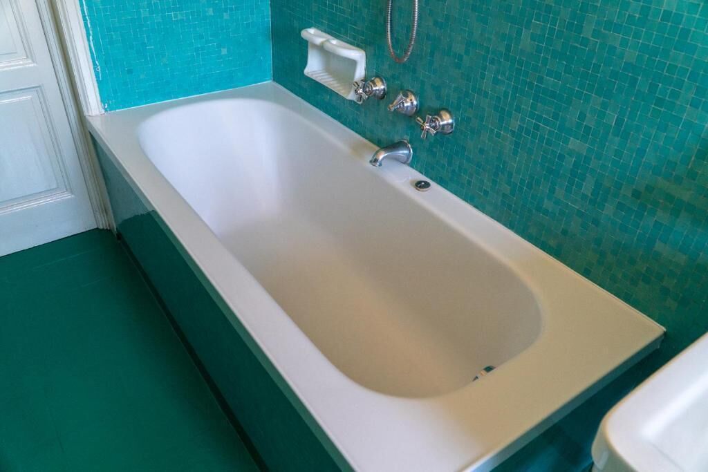 A modern bathroom with a large bathtub, a white sink, and a shower area.