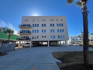 A multi-story building with a parking garage, balconies, and a clear sky. - The Vue by Panhandle Getways (Port St. Joe)