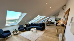 Ein geräumiges Loft mit einem großzügigen Wohnbereich, einem Esstisch und einer Küche.