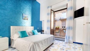 A bedroom with a bed, a nightstand, and a view of a balcony. - Marescala vacation - Tarantino House, cozy apartment in the historic center (Sorrento)
