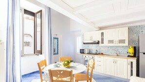 A bright kitchen with white cabinets, a microwave, and a yellow coffee machine. - Marescala vacation - Tarantino House, cozy apartment in the historic center (Sorrento)