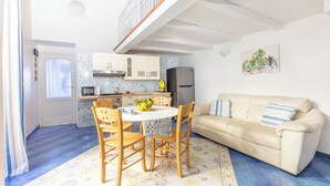 A compact living space with a dining area, a sofa, and a kitchen. - Marescala vacation - Tarantino House, cozy apartment in the historic center (Sorrento)