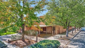 A residential property with a covered patio, a driveway, and a street view. - Inviting Remodeled Guest House in Central Nob Hill (Albuquerque)
