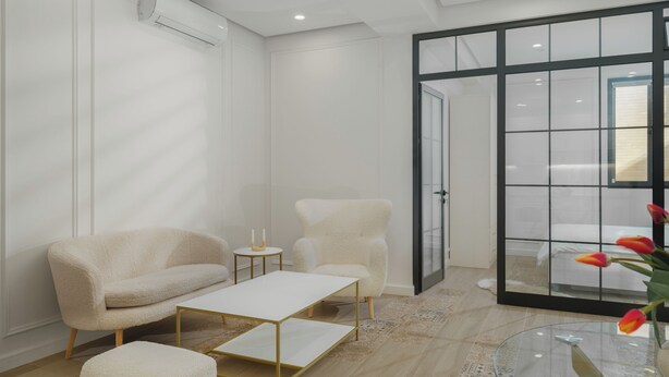 Ein modernes, minimalistisches Zimmer mit einer Couch, einem Couchtisch und einem Glastisch mit Blumen.