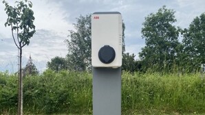 A standalone, rectangular, grey utility box with a round dial on top, labeled "ABB," set in a grassy area with trees in the background. - Bed and breakfast Le Rucher des Combes - Chambre Vézère (Fleurac)