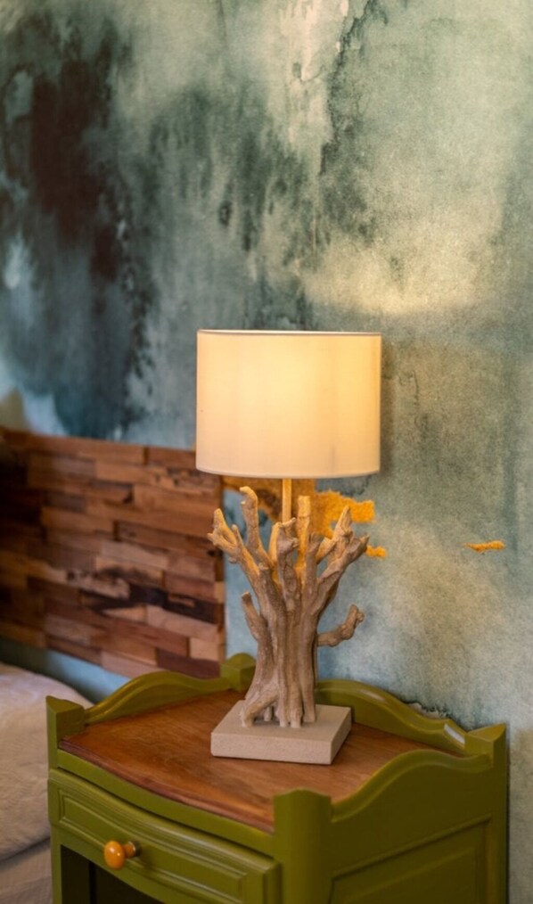 A lamp with a tree-shaped base on a green nightstand.