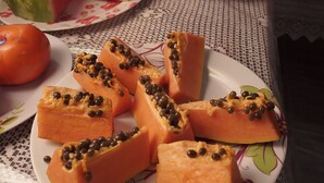 A table with plates of food including watermelon, papaya, and bread. - Pousada Centaurus (Alto Paraíso de Goiás)