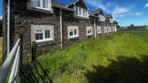 Un bâtiment en pierre doté de nombreuses fenêtres et d’un toit en pente.