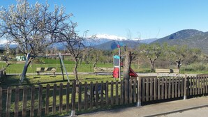 A park with a wooden fence, benches, and a playground. - Casa Alegria de Lamata. Newly built, ground floor, accessible. (Lamata)