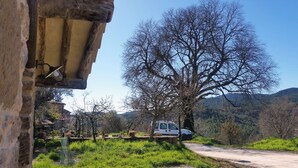 A rustic stone building with a wooden beam and a hanging light fixture. - Casa Alegria de Lamata. Newly built, ground floor, accessible. (Lamata)