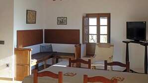 A bedroom with a wooden headboard bed, a desk, a chair, a television on a stand, and a window with a view outside. - Casa Alegria de Lamata. Newly built, ground floor, accessible. (Lamata)
