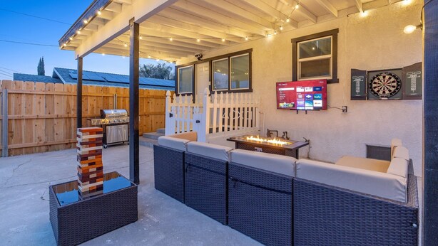Une terrasse extérieure dotée d’un foyer, de sièges et d’un jeu de fléchettes.