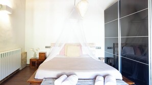 A bedroom with a bed under a canopy, a wooden nightstand, a radiator, and a large window. - Bel House fantastic property located in the exclusive urbanization Res.Begur (CT)