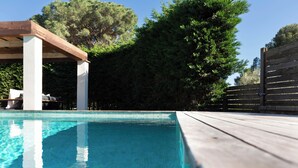 A clear swimming pool with wooden deck and a pergola structure. - Bel House fantastic property located in the exclusive urbanization Res.Begur (CT)