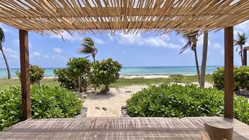 A wooden deck with a view of the beach and ocean.
