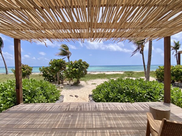 A wooden deck with a view of the beach and ocean. - Windward Mayreau Resort (Mayreau Island)