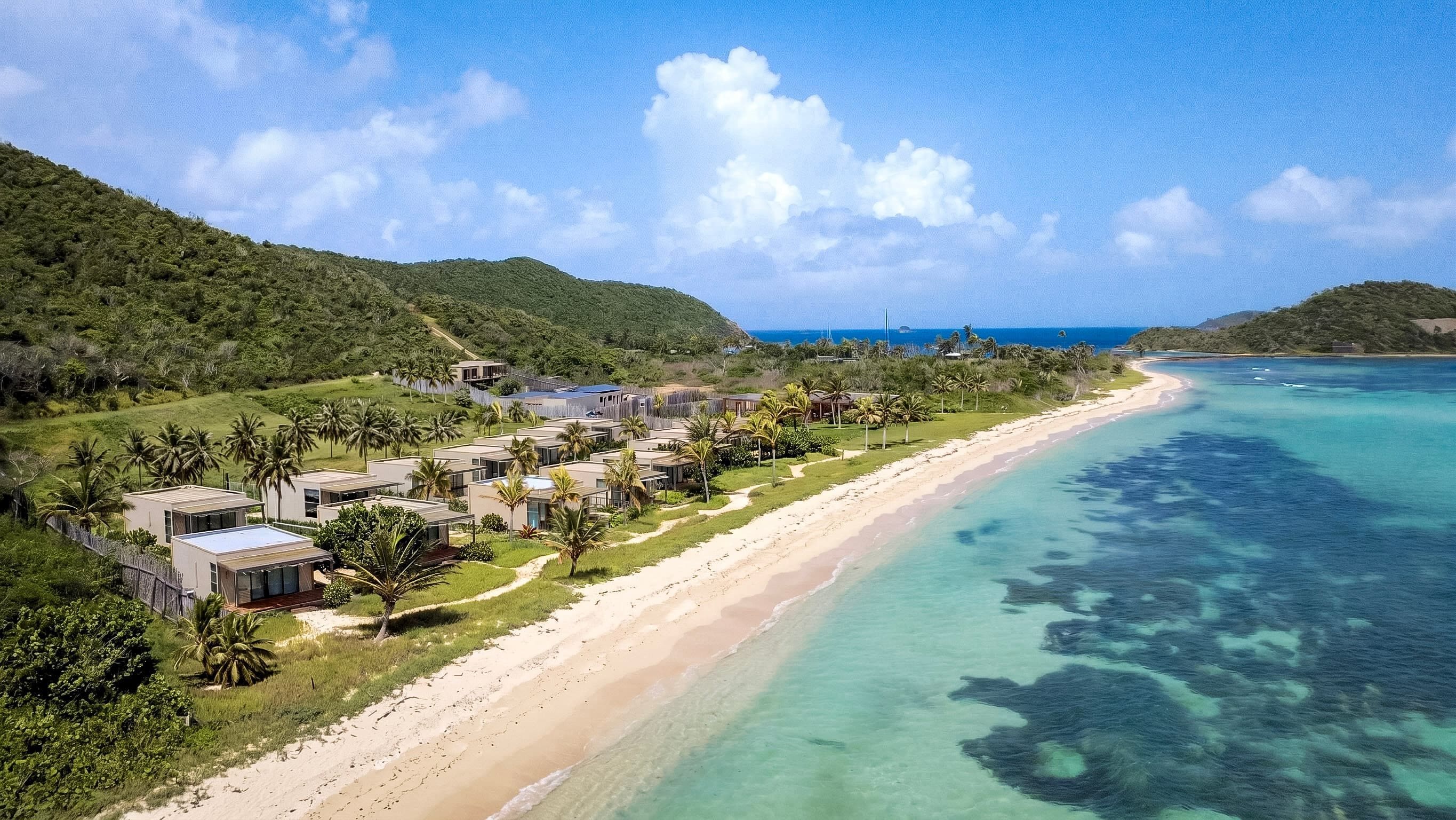 A coastal resort with beachfront villas, clear turquoise waters, and lush greenery.