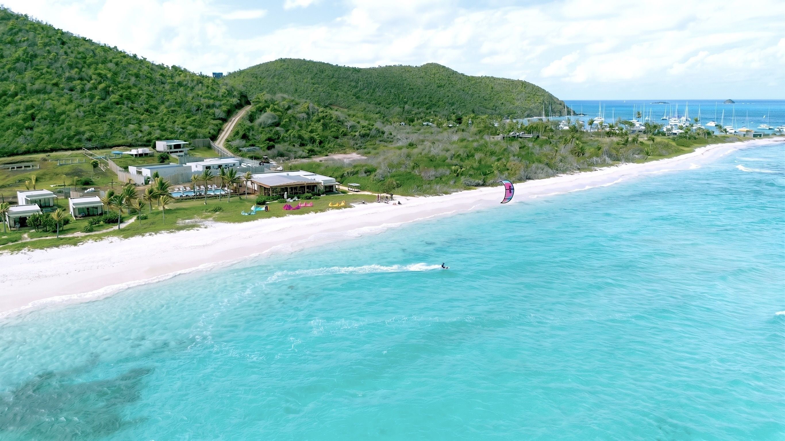 A coastal resort with beachfront accommodations, a sandy beach, and a clear view of the ocean.