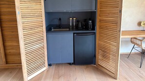 A compact kitchen with a built-in refrigerator, a sink, and a coffee maker. - Windward Mayreau Resort (Mayreau Island)