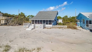 A beachfront property with a large house featuring a covered porch and a fenced front yard. - Lighthouse- enjoy the water, bask in the view (Alligator Point)