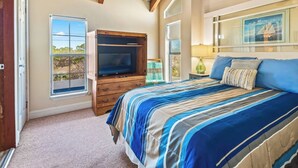 A bedroom with a bed, a wooden cabinet, a window, and a painting on the wall. - Lighthouse- enjoy the water, bask in the view (Alligator Point)