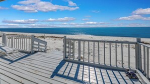 A wooden deck with a railing overlooking a beach. - Lighthouse- enjoy the water, bask in the view (Alligator Point)