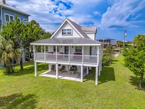 A two-story house with a balcony, surrounded by a well-maintained lawn and trees. - Relax at Shell Point Beach!  Bring your boat to park at the dock. (Crawfordville)
