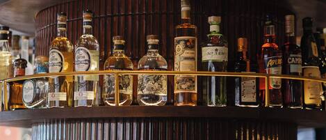 Un bar de varios niveles con diversas botellas de licor.