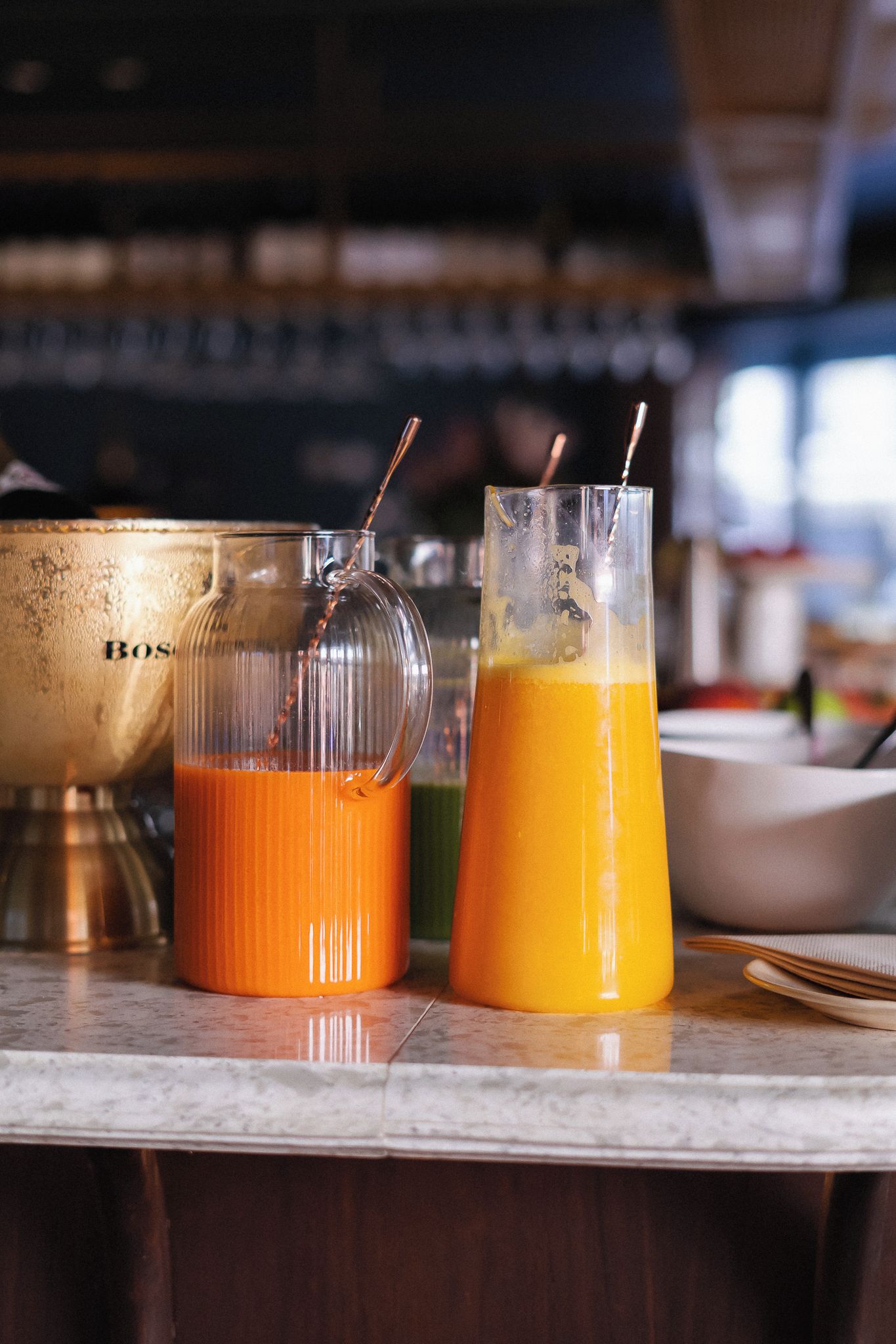 Two glass containers on a countertop, one with a metallic object labeled 'Bosch' and the other with a straw.