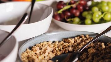 A table with bowls of food, including fruits and granola.
