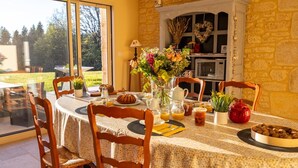 A dining area with a table set for breakfast, including bread, fruit, and beverages. - Chambre d'hôtes Le Rucher des Combes - Lascaux room (Fleurac)