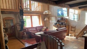A rustic interior with a leather sofa, wooden staircase, and a dining area. - Large house near the slopes, La Salle-les-Alpes (La Salle-les-Alpes)