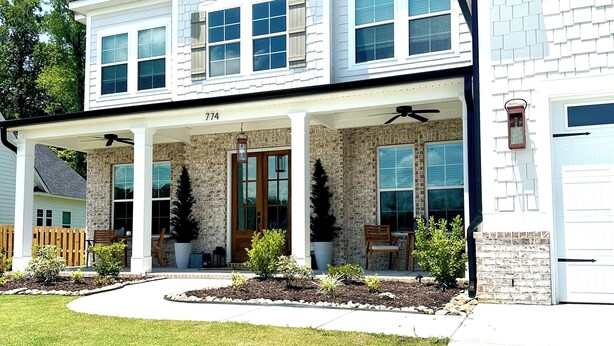 A two-story house with a covered porch, a brick facade, and a number '774' on the front. - Charming 5-bedroom Masters Rental house in River Oaks  in quaint Evans (Evans)