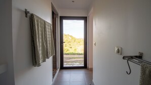 A hallway with a door leading to a balcony with a view of a hillside. - Casarone : Havre de paix avec vue sublime sur Calvi, piscine et nature (Calvi)