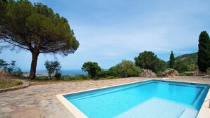 A rectangular swimming pool with clear blue water, surrounded by stone tiles and a stone wall. - Casarone : Havre de paix avec vue sublime sur Calvi, piscine et nature (Calvi)